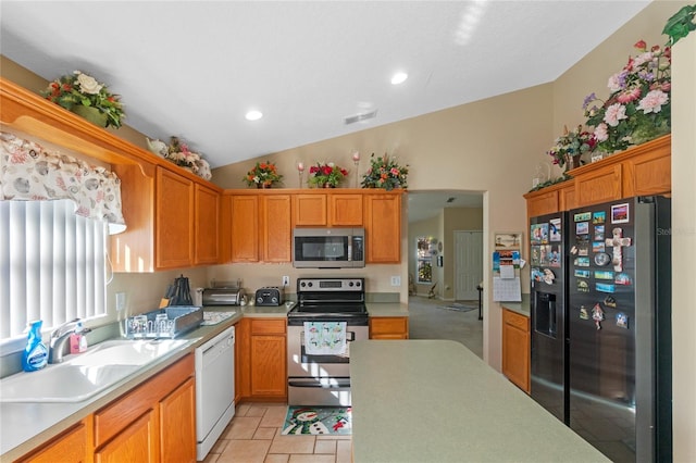 kitchen with sink, light tile patterned floors, stainless steel appliances, and lofted ceiling