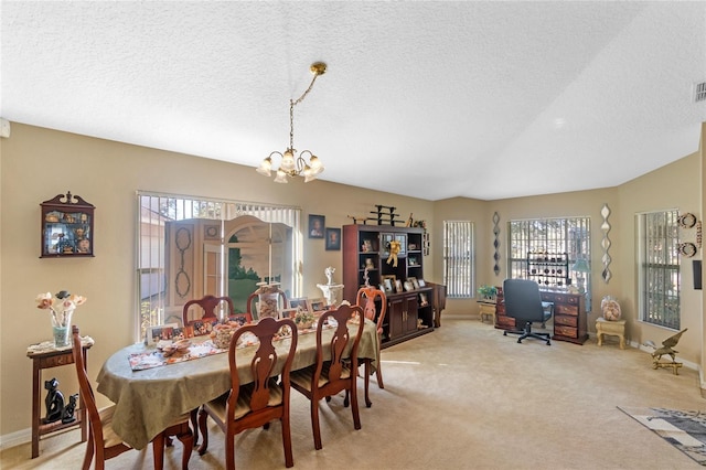 carpeted dining area with a notable chandelier, plenty of natural light, and a textured ceiling