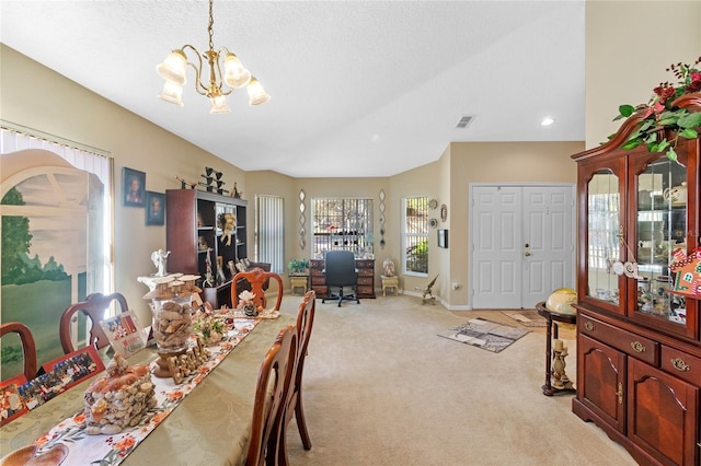 carpeted dining space with a chandelier and a textured ceiling