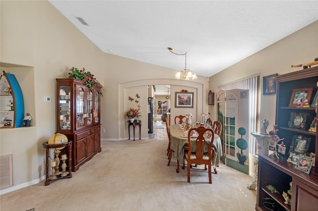 carpeted dining space with lofted ceiling and an inviting chandelier