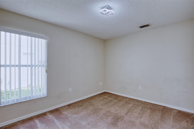 unfurnished room featuring a textured ceiling and carpet floors