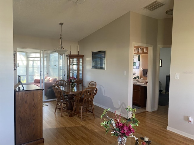 dining area featuring light hardwood / wood-style floors and lofted ceiling