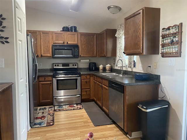 kitchen with sink, light wood-type flooring, and appliances with stainless steel finishes