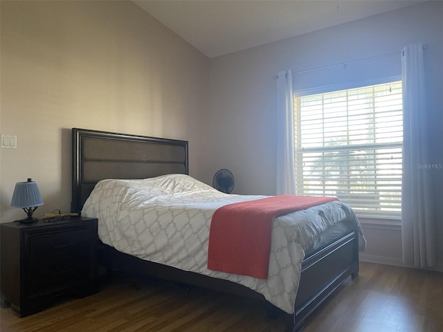 bedroom with wood-type flooring and vaulted ceiling