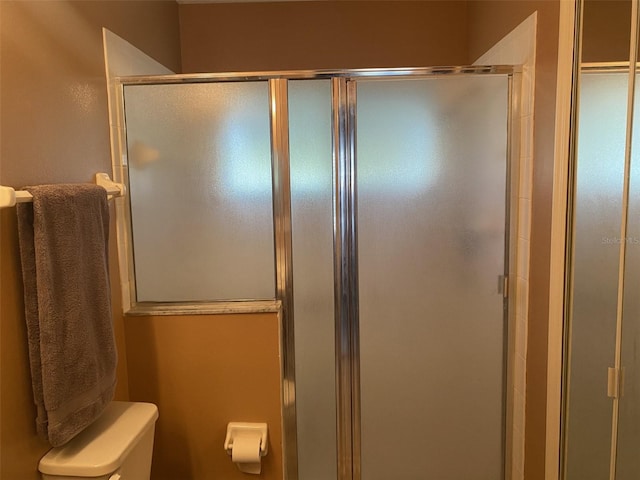 bathroom with toilet and a shower with shower door