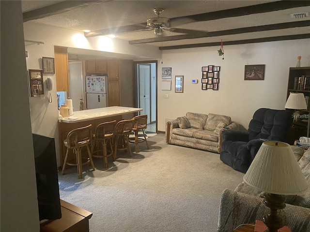 living room with carpet flooring, ceiling fan, a textured ceiling, bar, and beam ceiling