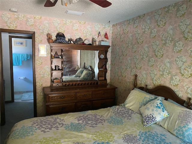 bedroom featuring ceiling fan, a textured ceiling, and connected bathroom