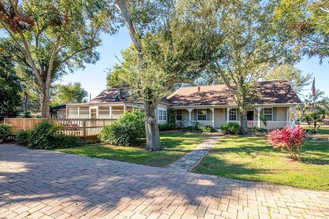 ranch-style home with covered porch and a front yard