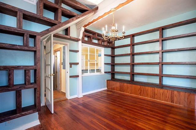 basement featuring a notable chandelier and dark wood-type flooring