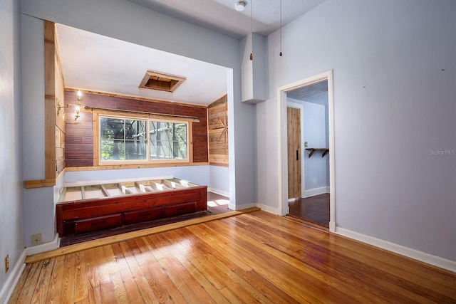 interior space with wood walls and hardwood / wood-style flooring