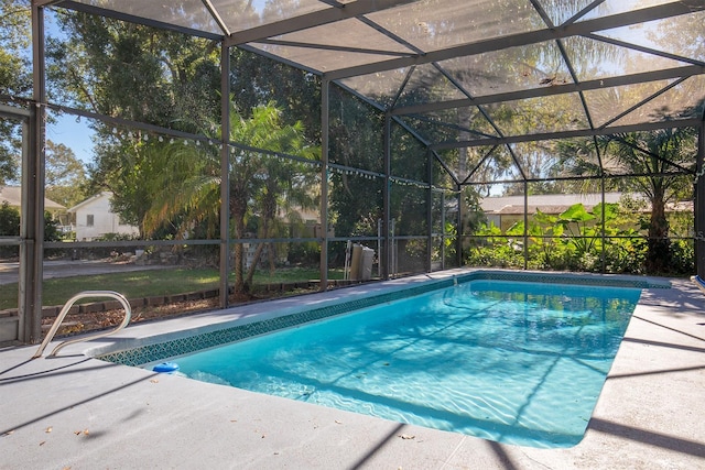 view of pool featuring glass enclosure and a patio area