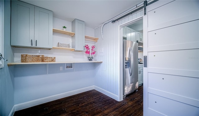 kitchen with dark hardwood / wood-style floors, a barn door, and stainless steel refrigerator with ice dispenser