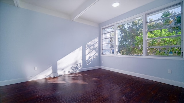 empty room with dark hardwood / wood-style floors and beam ceiling