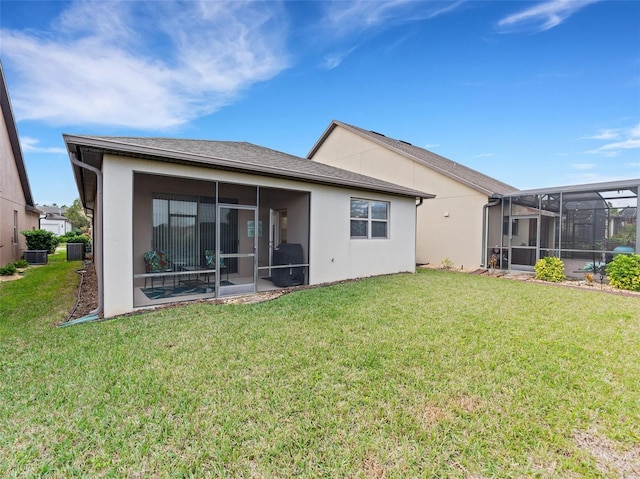 back of house with a lawn, a lanai, and central AC unit