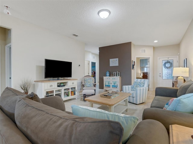 tiled living room featuring a textured ceiling