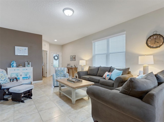 tiled living room featuring a textured ceiling