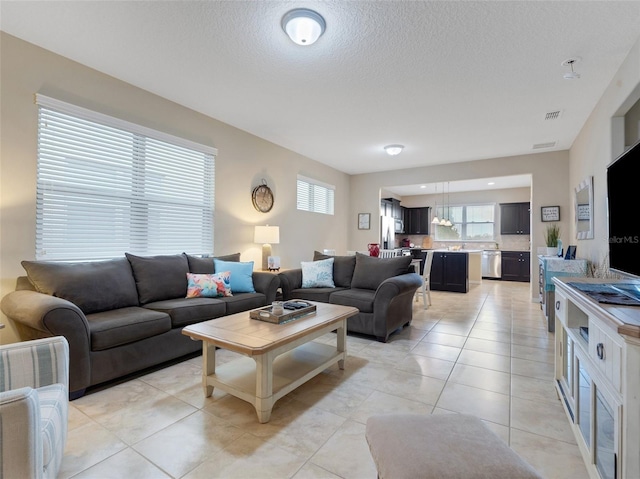 tiled living room featuring a textured ceiling