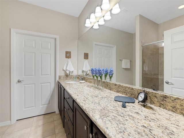 bathroom with tile patterned flooring, vanity, and walk in shower