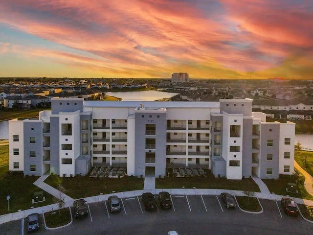 aerial view at dusk featuring a water view