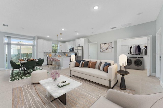 living room featuring recessed lighting, visible vents, washer and clothes dryer, and light tile patterned floors