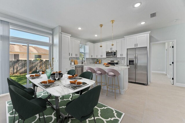 dining space featuring light tile patterned flooring, baseboards, visible vents, and recessed lighting