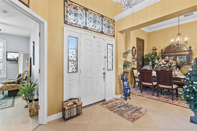 entrance foyer featuring crown molding, light tile patterned floors, and an inviting chandelier