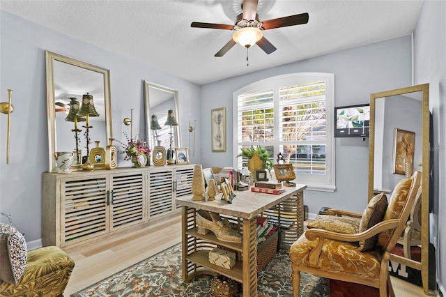 interior space featuring ceiling fan, a textured ceiling, and light wood-type flooring