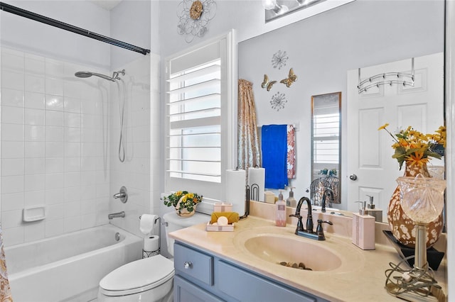 full bathroom featuring vanity, tiled shower / bath, and toilet