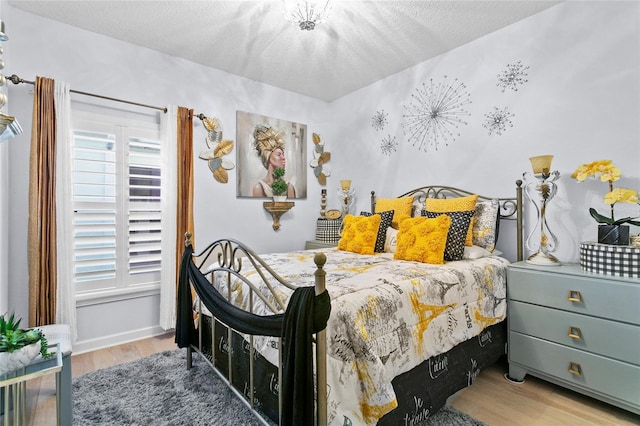 bedroom with light hardwood / wood-style floors and a textured ceiling