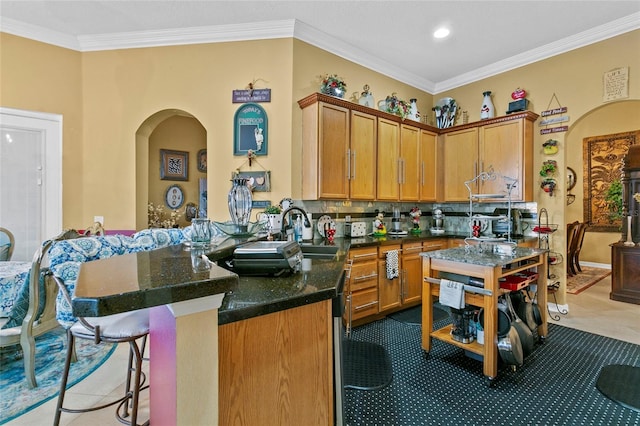 kitchen featuring tasteful backsplash, kitchen peninsula, sink, and ornamental molding