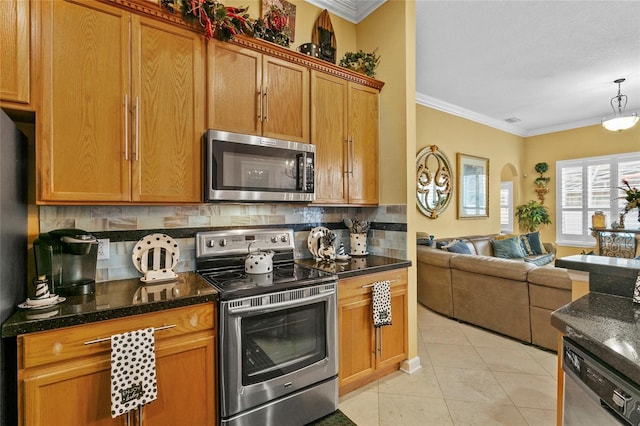 kitchen with backsplash, dark stone counters, light tile patterned floors, ornamental molding, and appliances with stainless steel finishes