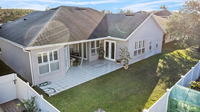 rear view of house with french doors, a yard, and a patio