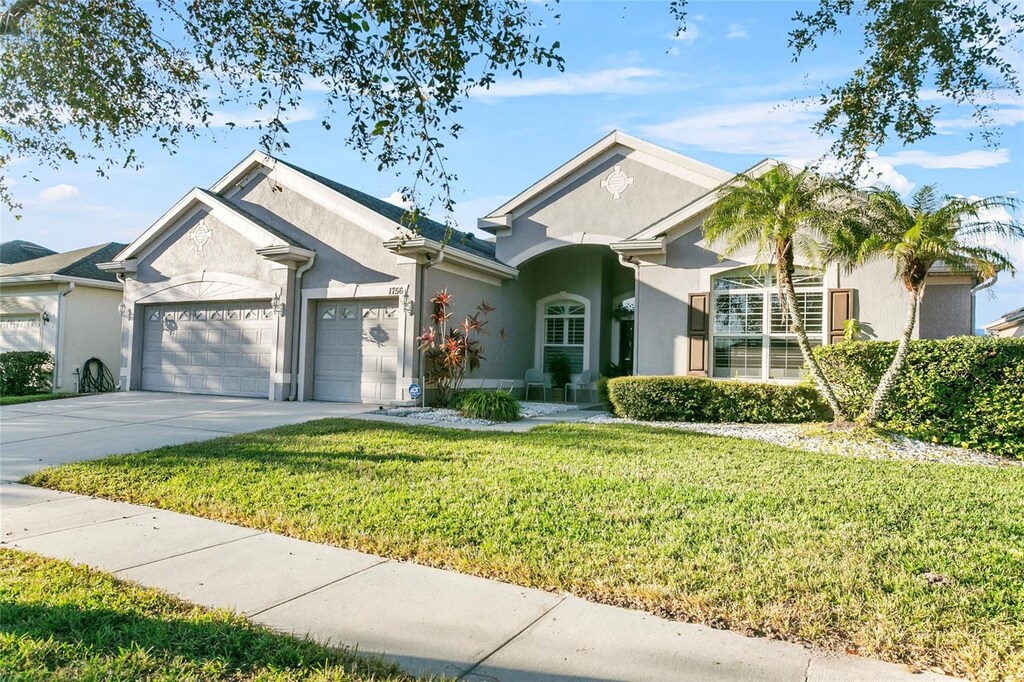 view of front of property with a garage and a front lawn