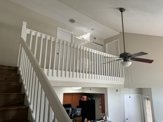 stairs featuring ceiling fan and a textured ceiling