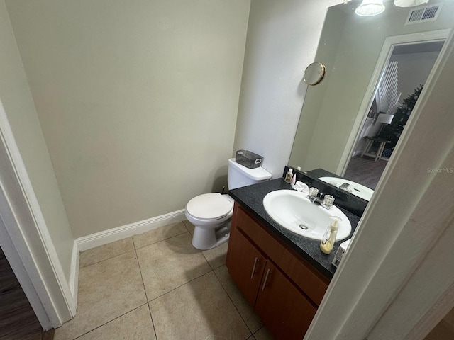 bathroom with tile patterned flooring, vanity, and toilet