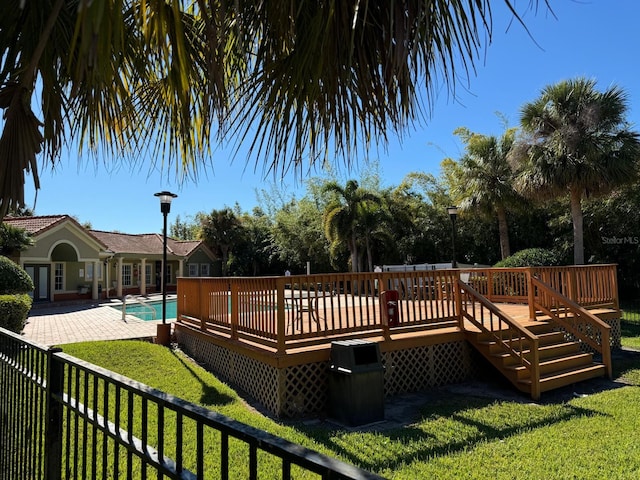 view of pool with a patio, a deck, and a lawn