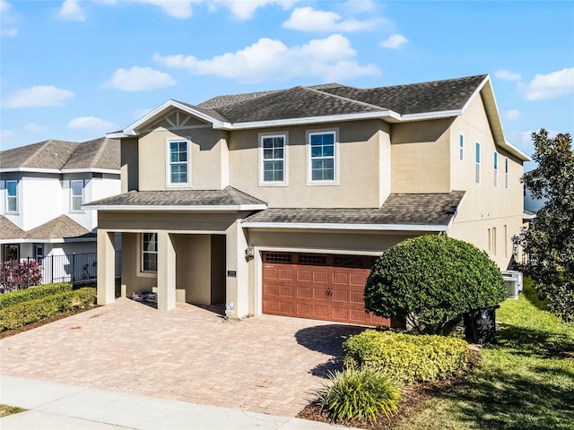 7639 Wilmington Loop, Kissimmee, FL 34747 - view of front of house with stucco siding, a garage, decorative driveway, and roof with shingles