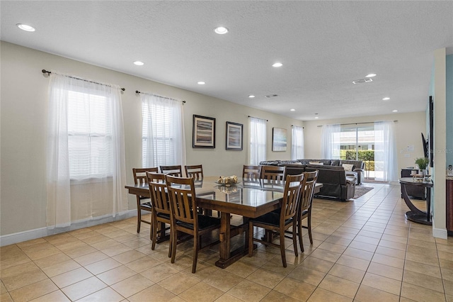 tiled dining area with a textured ceiling