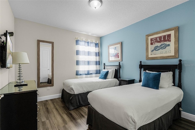 bedroom featuring a textured ceiling and dark hardwood / wood-style floors