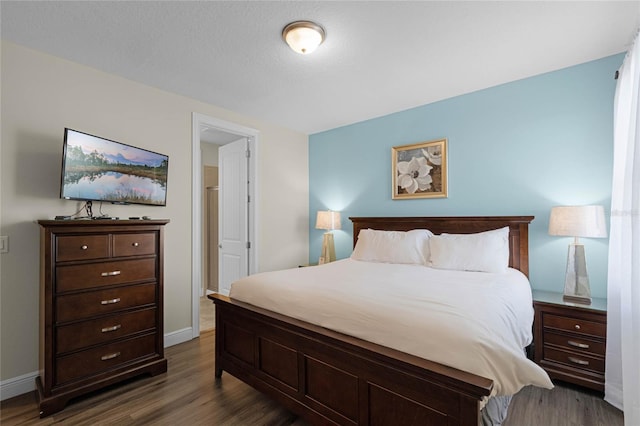 bedroom with dark hardwood / wood-style floors