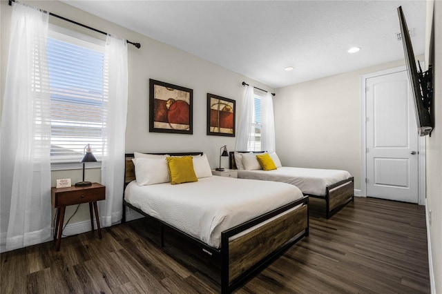 bedroom featuring a textured ceiling and dark hardwood / wood-style flooring