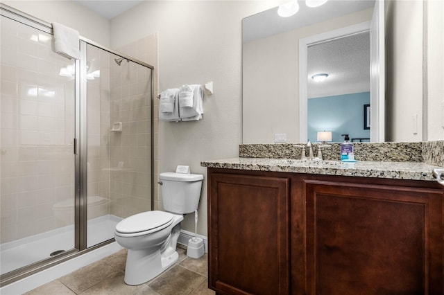 bathroom featuring a textured ceiling, vanity, tile patterned flooring, toilet, and a shower with shower door