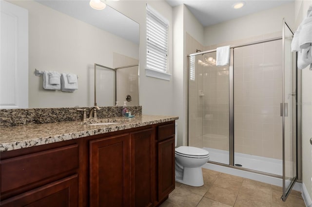 bathroom with tile patterned flooring, vanity, and walk in shower