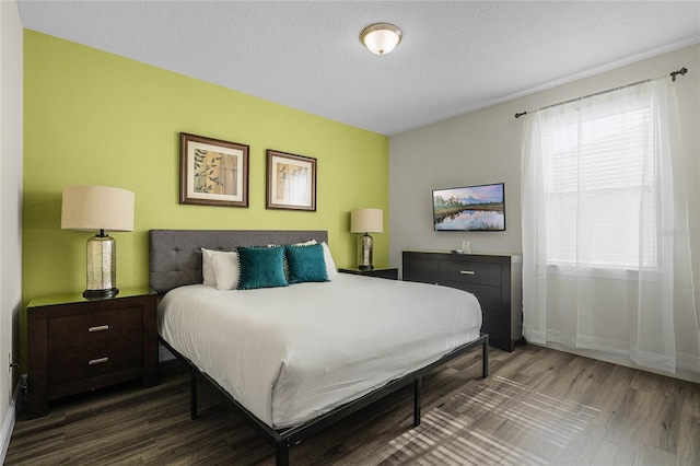 bedroom with a textured ceiling and dark wood-type flooring