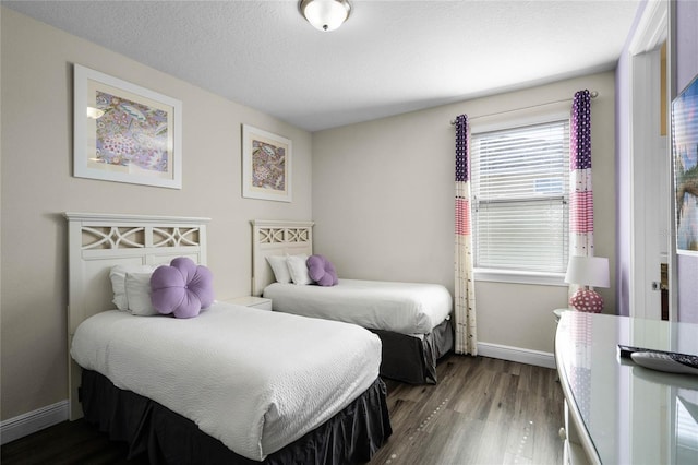 bedroom with a textured ceiling and dark hardwood / wood-style flooring