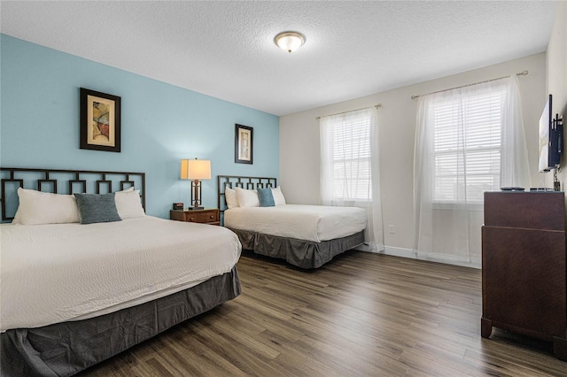 bedroom featuring dark wood-type flooring and a textured ceiling