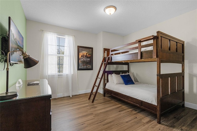 bedroom with a textured ceiling and dark hardwood / wood-style floors