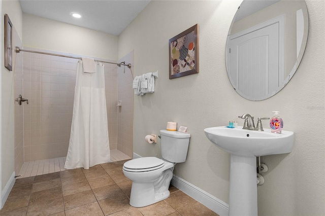 bathroom featuring tile patterned floors, sink, toilet, and walk in shower