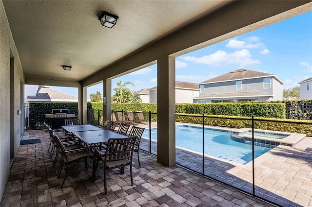 view of patio featuring a grill and a pool with hot tub