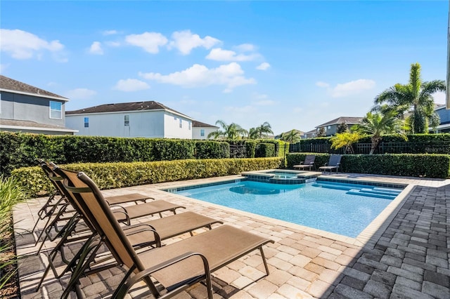 view of pool with a patio area and an in ground hot tub